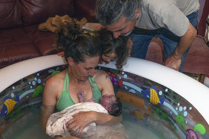 Morgan Cooper holds newborn Lourice as her husband Saleh Totah and 4-year-old son look on. Lourice was delivered in June in a home birth in an inflatable swimming pool in the family's home in the West Bank city of Ramallah. They planned to travel to the U.S. but faced bureaucratic obstacles.