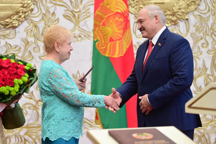 Lidia Yermoshina (left), chairperson of the Belarusian Central Election Commission, hands over a presidential ID to President Alexander Lukashenko during an inauguration ceremony Wednesday at Independence Palace in Minsk.