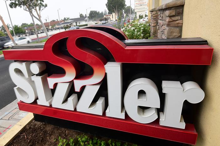 Sizzler USA has filed for bankruptcy as a result of the COVID-19 pandemic and related restrictions. Here, drivers pass a closed Sizzler restaurant in Montebello, Calif.