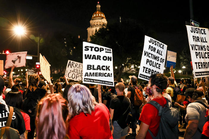 People protest the grand jury decision in the Breonna Taylor case in front of the Colorado state Capitol in Denver on Wednesday. As the protest was breaking up, a motorist drove through a small crowd of protesters who had yelled at the driver to turn around.