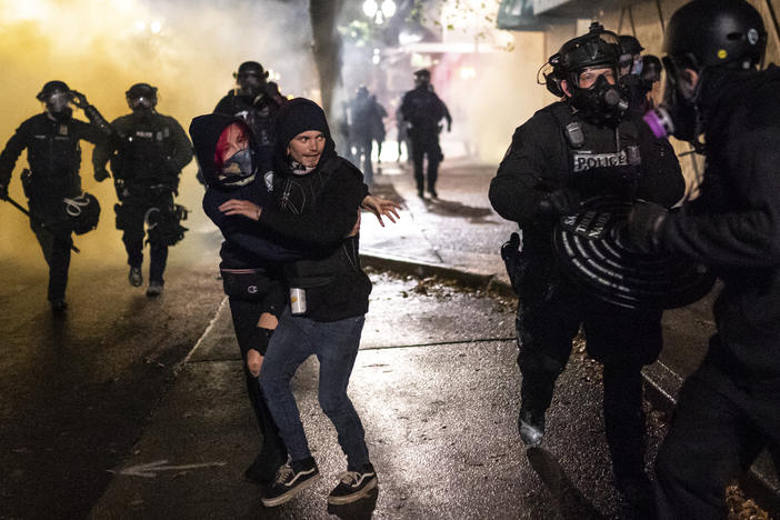 Protesters look for an escape while Portland police disperse a crowd in Portland, Ore. Wednesday. Violent protests erupted following the results of a grand jury investigation into the police shooting death of Breonna Taylor.