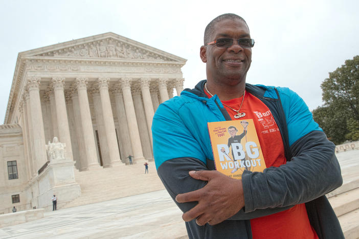 Bryant Johnson, who was Justice Ruth Bader Ginsburg's personal trainer, poses at the court in 2017 with his book, "The RBG Workout: How She Stays Strong ... and You Can Too!"