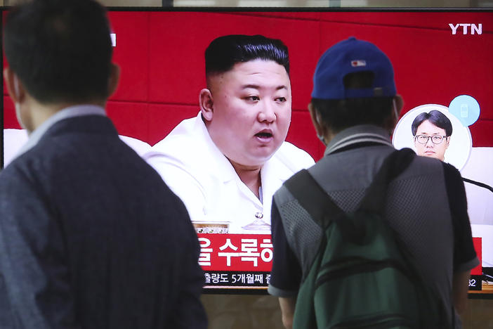 People at the Seoul Railway Station in Seoul watch a news program Friday showing a file image of North Korean leader Kim Jong Un, who said he was sorry over the killing of a South Korean fisheries official near the two countries' disputed sea boundary.