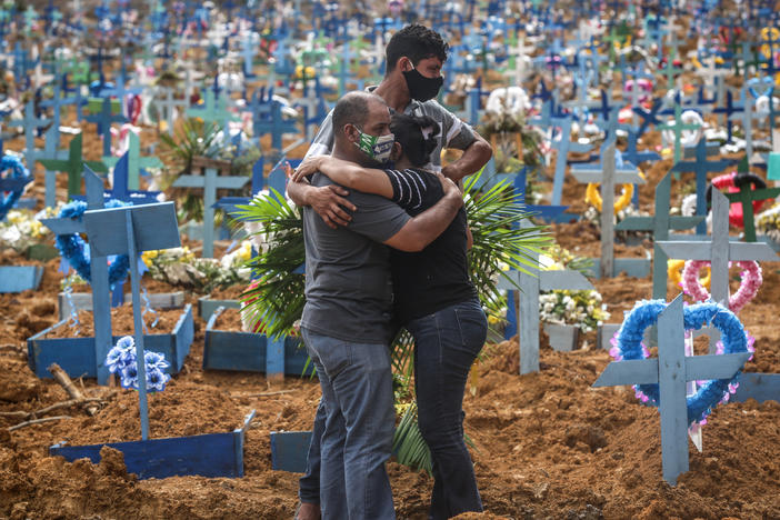Relatives at a mass burial of pandemic victims at the Parque Taruma cemetery in Manaus, Brazil, mourn a family member.