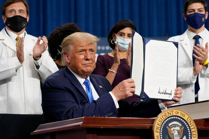 President Trump holds up an executive order after delivering remarks on health care in Charlotte, N.C., on Thursday.