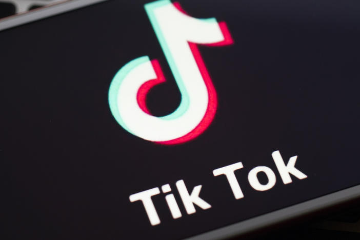 In this photo illustration a mobile phone screen displays TikTok logo in front of a keyboard.