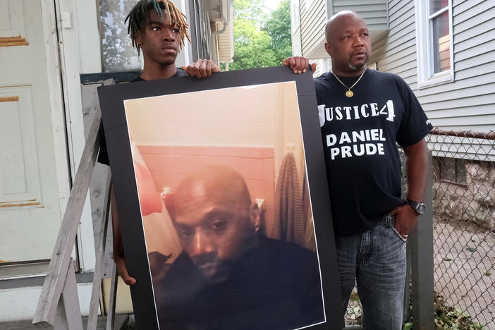 Family members Armin Prude (left) and Joe Prude stand with a picture of Daniel Prude in Rochester, N.Y., Thursday, Sept. 3, 2020. While suffering a mental health crisis, Prude, 41, suffocated after police in Rochester put a "spit hood" over his head while being taken into custody. He died March 30 after he was taken off life support, seven days after the encounter with police.