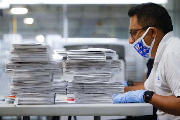 A worker prepares to check stacks of ballots in July at a Board of Elections facility in New York City. The city's election board says it will send about 100,000 new absentee ballots to voters after mailing out error-filled ones.