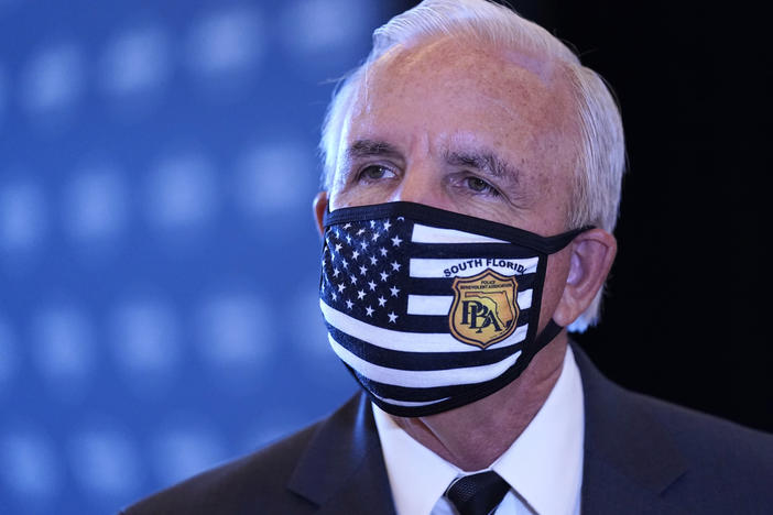 Miami-Dade County Mayor Carlos Gimenez speaks with the news media, last month, at Hard Rock Stadium in Miami Gardens, Fla. Gimenez said Tuesday that he would keep some COVID-19 restrictions in place despite an order by Fla. Gov. Ron DeSantis.