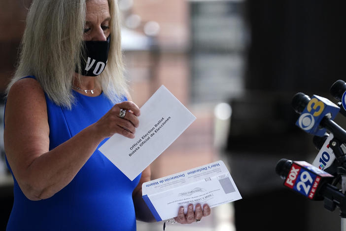 Philadelphia City Commissioner Lisa Deeley opens a sample mail-in ballot during a news conference at the opening of a satellite election office at Temple University's Liacouras Center on Sept. 29 in Philadelphia.
