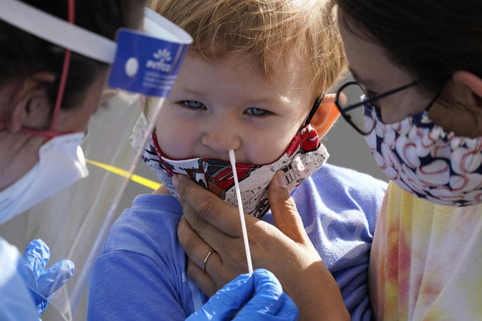 Penny Brown, 2, is held by her mother, Heather Brown, as her nose is lightly swabbed during a test for the coronavirus in Seattle last month. A survey of state health department website data shows severe illness and death among children with COVID-19 is rare.