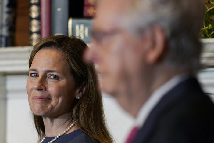Supreme Court nominee Judge Amy Coney Barrett looks over to Senate Majority Leader Mitch McConnell of Kentucky on Capitol Hill Tuesday.