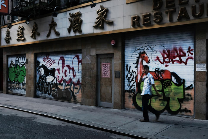 A man passes by a closed restaurant in New York City's Chinatown on Aug. 10, 2020. The unemployment rate for Asian Americans has surged amid the pandemic, a trend that has been overlooked amid the widespread economic misery.