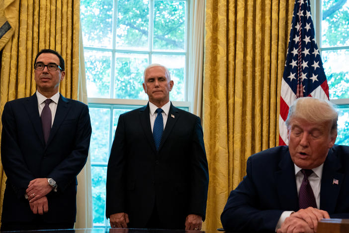 President Trump, flanked by Treasury Secretary Steven Mnuchin (left) and Vice President Pence last month in the Oval Office. Pence and Mnuchin are in the immediate line of succession if Trump is not able to perform his duties.