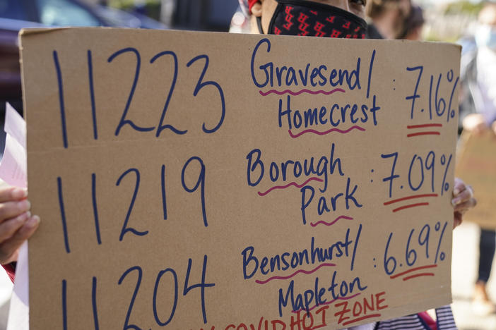 Teachers and staff protest outside Franklin D. Roosevelt High School as they call for more and better COVID-19 testing and precautions on Friday in New York City. The ZIP codes listed on this sign are among those soon to face restrictions by the city.