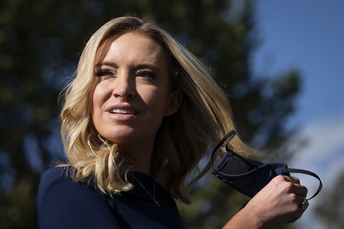 White House press secretary Kayleigh McEnany takes off her face covering before speaking with reporters outside the West Wing of the White House on Friday, the day President Trump announced he had tested positive for the virus.