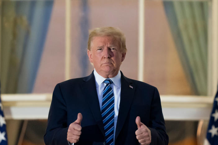 President Donald Trump gives thumbs up as he stands on the Blue Room Balcony upon returning to the White House on Monday.