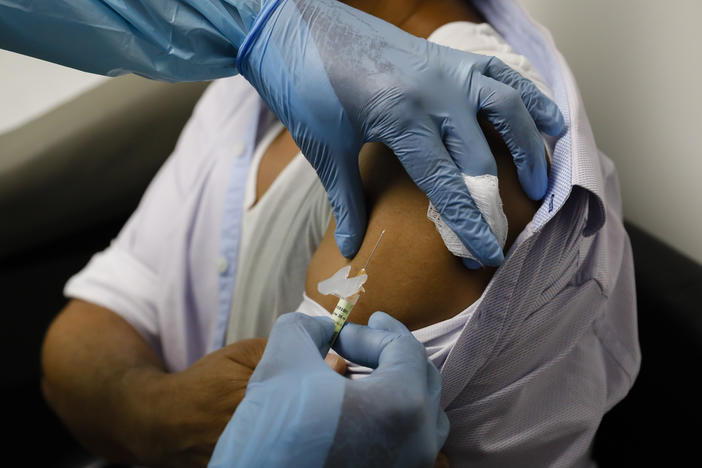 A volunteer in a clinical trial for an experimental COVID-19 vaccine receives an injection last month at Research Centers of America in Hollywood, Fla.