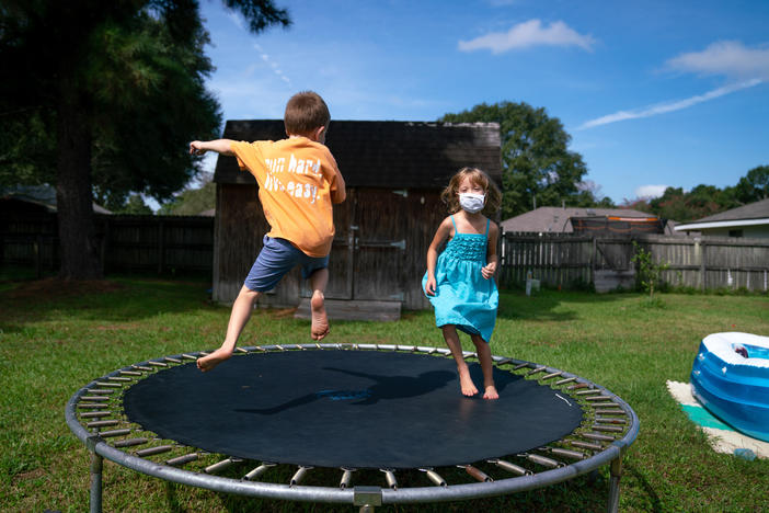 Lachlan (left) and Lillian Barilleau play in the backyard of their home in Central, La. They were displaced from the house for months after a flood in 2016.