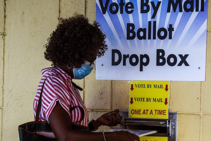 A woman drops her ballot by mail at Broward County Supervisor Of Elections Office in Lauderhill, Fla., on Monday.