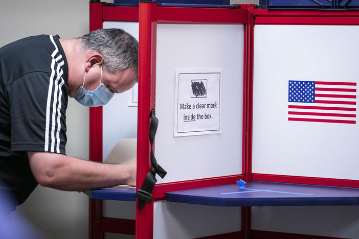 A man casts his ballot for the 2020 presidential election at an early voting location in Alexandria, Va. Voters in Virginia will now be able to register until 11:59 p.m. on Thursday, in person or online.
