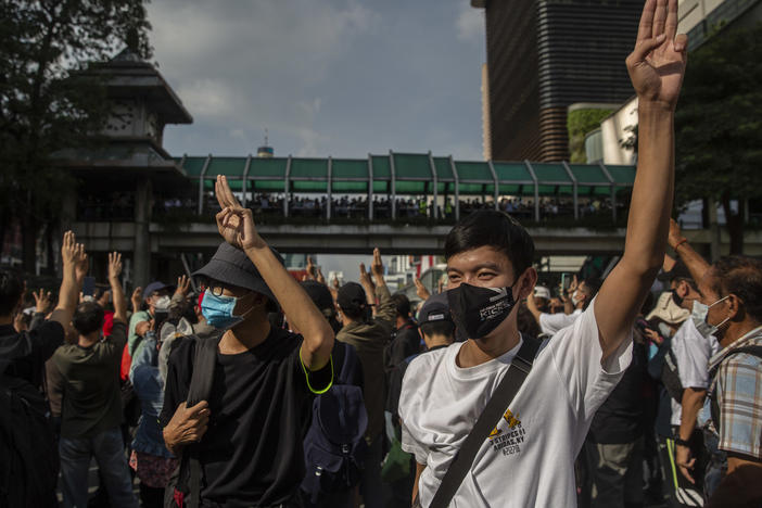 Pro-democracy protesters hold up a three-fingered salute Thursday at Bangkok's Ratchaprasong intersection.