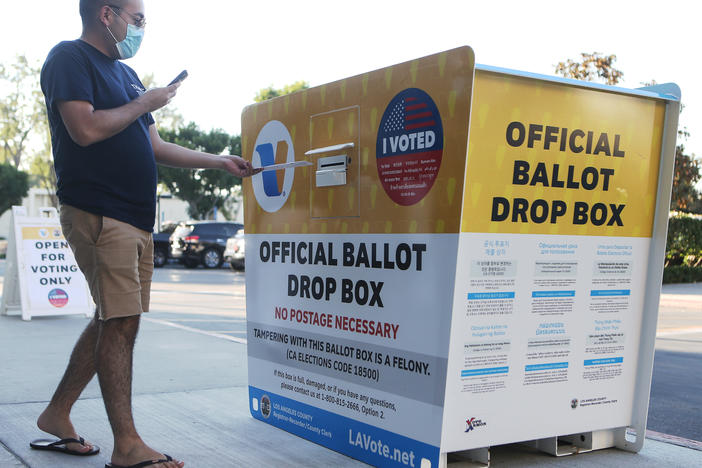 A voter places a ballot in an official mail-in ballot drop box outside the Los Angeles County Registrar's office this week in Norwalk, Calif. The California Republican Party has said it will not comply with a state cease-and-desist order to halt usage of the GOP's unofficial ballot drop boxes.