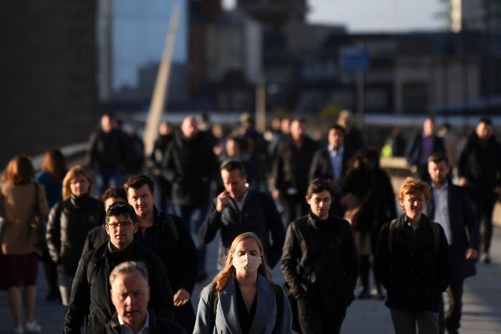 Commuters walk over London Bridge toward the city during the morning rush hour on Thursday. The city and other large areas are set to be under a high alert for the coronavirus.