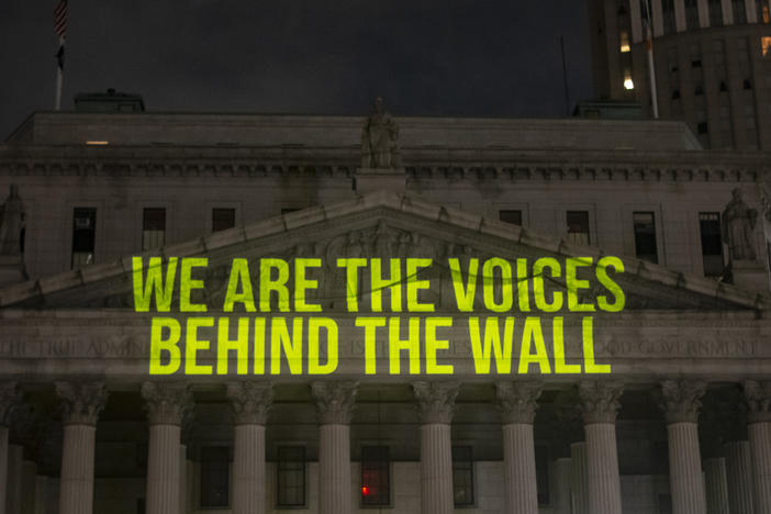 "The Writing On The Wall" art installation projects writings by incarcerated people onto the sides of buildings, such as The New York State Supreme Court Building, above.