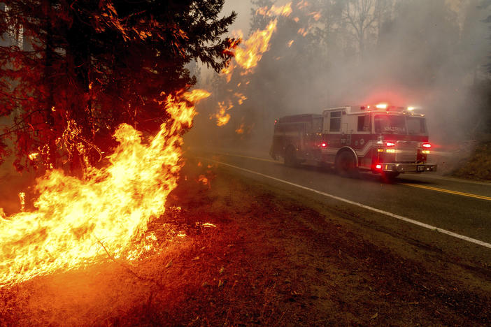 A firetruck drives along state Highway 168 last month while battling the Creek Fire in the Shaver Lake community of Fresno County, Calif.