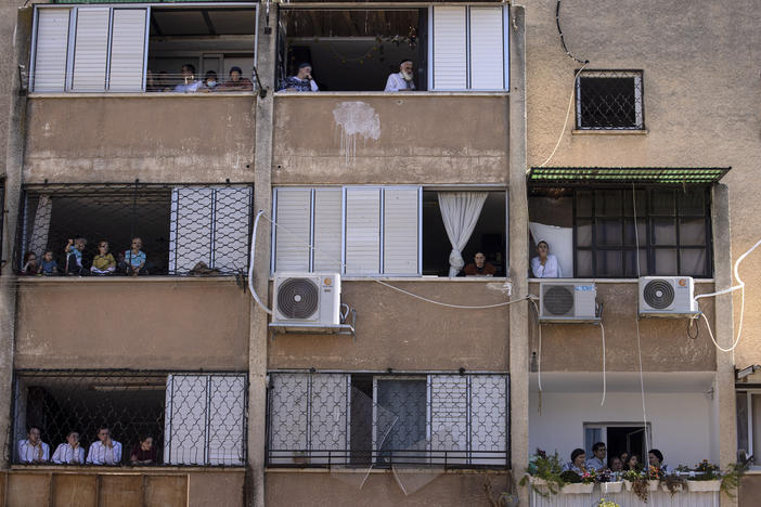 Ultra-Orthodox Jews watch a funeral for Rabbi Mordechai Leifer from their balconies in the port city of Ashdod, Israel, on Oct. 5. The rabbi, who had been the spiritual leader of a small ultra-Orthodox community founded a century ago in Pittsburgh, died after being infected with COVID-19.