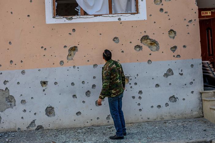 Movsumov Qowkar, 32, checks his neighbor's home damaged by shelling in the city of Terter early on Sunday.