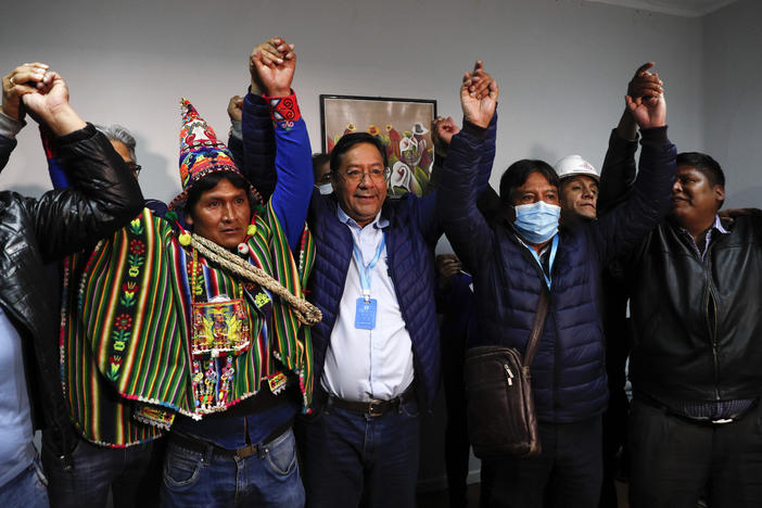 Bolivian presidential candidate Luis Arce (center) and running mate David Choquehuanca (second right) celebrate during a news conference Monday in La Paz, Bolivia.