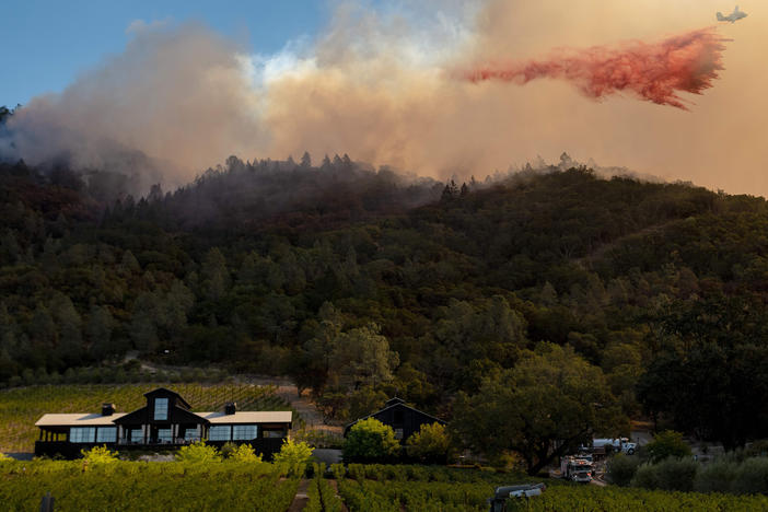 A California Department of Forestry and Fire Protection airplane drops fire retardant along a burning hill during the Glass Fire in Calistoga, Calif., in September. California is one of two states to require wildfire risk be disclosed to new homebuyers.