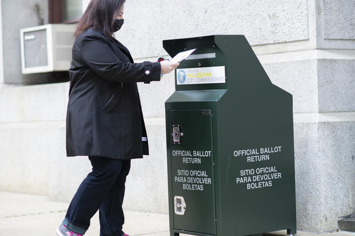 A voter casts her early-voting ballot at a drop box outside City Hall in Philadelphia on Oct. 17.
