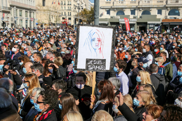 Demonstrators wearing face masks gather Sunday in Marseille, France, to pay tribute to teacher Samuel Paty, who was beheaded after he showed his class cartoons depicting the Prophet Muhammad.