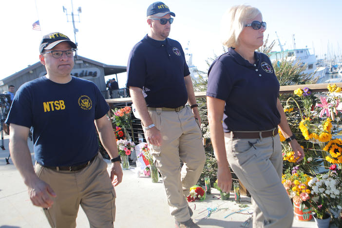 National Transportation Safety Board member Jennifer Homendy (right) walks with other NTSB officials past a makeshift memorial for victims of the Conception boat fire in September 2019 in Santa Barbara, Calif.