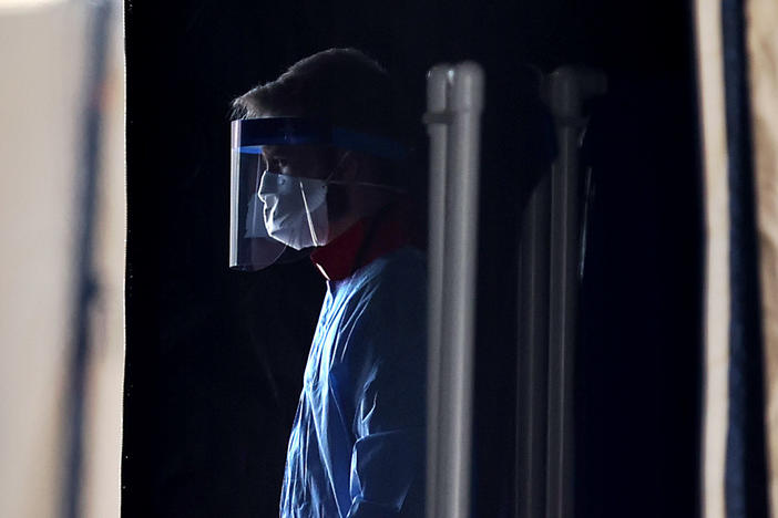 A health care worker prepares to screen people for the coronavirus at a testing site in Landover, Md., in March.