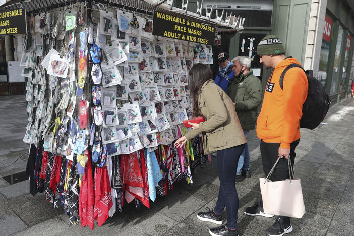 Shoppers buy face masks on O'Connell Street in Dublin, Ireland, on Tuesday. Ireland's government is putting the country at its highest level of coronavirus restrictions for six weeks in a bid to combat a rise in infections.