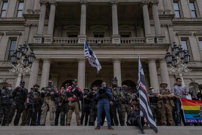 Far-right extremist "Boogaloo boys" stand on the steps of the capitol in Lansing, Mich., during a rally on Oct. 17. Michigan is one of five states with the highest risk of increased militia activity around the elections, according to a new report.