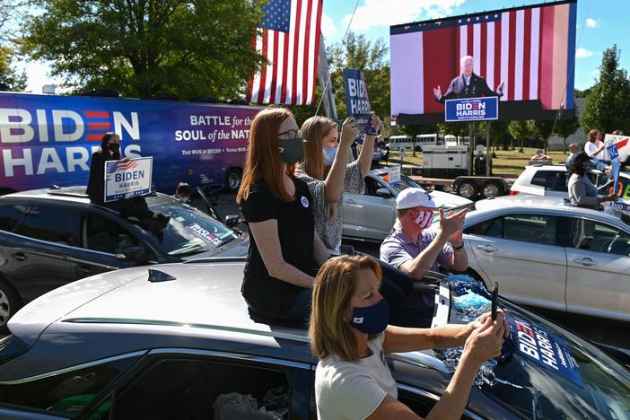 Supporters of Democratic presidential nominee Joe Biden sit atop their vehicles as they listen to him speak Sunday at Riverside High School in Durham, N.C.