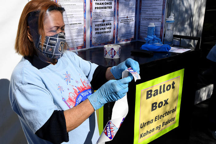 Volunteer Esmeralda Raymond gets a roll of "I Voted" stickers ready at a polling site in Las Vegas on the first day of in-person early voting on Oct. 17.