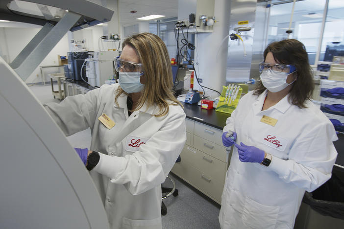 Eli Lilly researchers prepare cells to produce possible COVID-19 antibodies in a laboratory in Indianapolis. The drugmaker has asked the U.S. government to allow emergency use of its experimental antibody therapy.