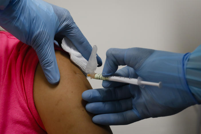A health worker injects a woman during clinical trials for a COVID-19 vaccine last month in Hollywood, Fla.