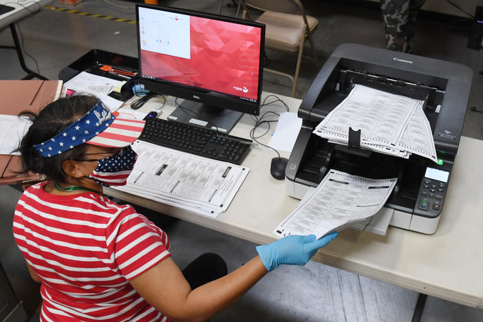 A Clark County, Nev., election worker scans mail-in ballots earlier this week in North Las Vegas. The state allows officials to count ballots received in advance of Election Day in order to speed the tabulation of results that evening.