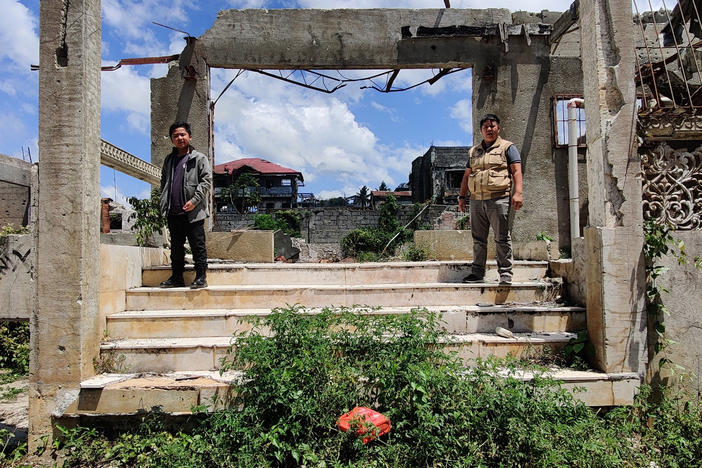 Zaqqir Ali Pacasum, 13, and Nawaz K. Lucman, 28 — Mustapha Alauya L. Pacasum's son and cousin, respectively — stand outside their destroyed ancestral home in Marawi City earlier this year.
