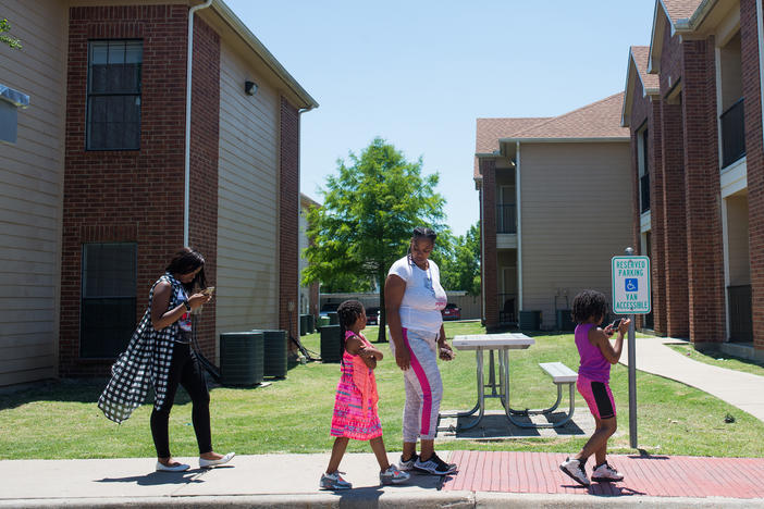 C'Artis Harris, walking with her children in 2017, was searching for housing that would accept her Section 8 voucher when NPR began following her in 2016. Today, Harris and her family still live in an area of high poverty.