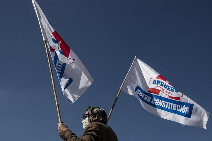 A man waves campaign flags in favor of a new constitution ahead of a referendum on the matter in Santiago, Chile, on Aug. 26. In a referendum on Sunday, Chileans will vote whether to scrap the constitution from the dictatorship of Gen. Augusto Pinochet.