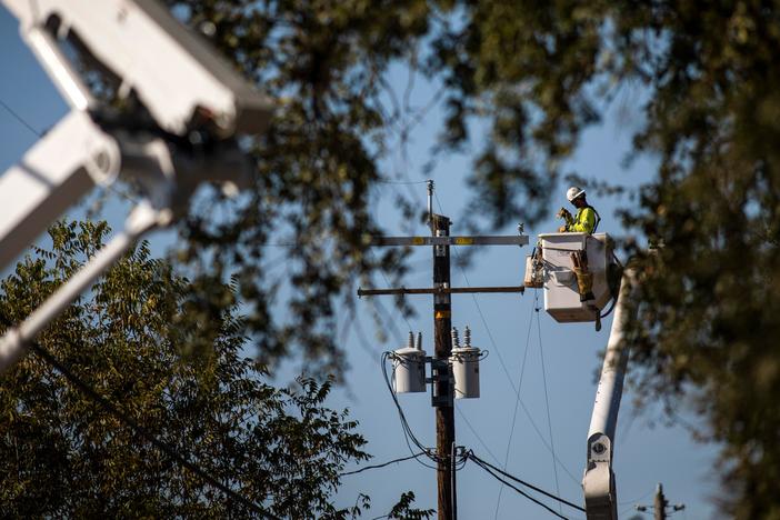 A PG&E contractor works on utility poles along Highway 128 near Geyserville, Calif., on October 31, 2019. The utility is shutting off power for hundreds of thousands in an effort to not spark wildfires.