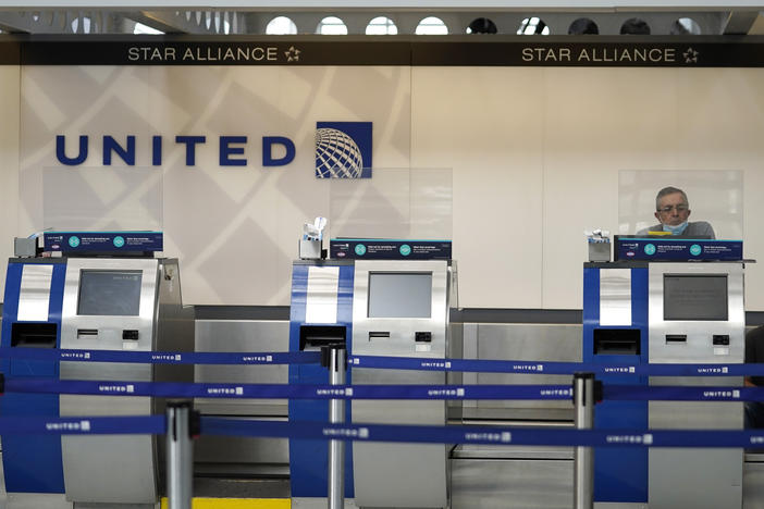 United Airlines employees work at ticket counters at Chicago's O'Hare International Airport on Oct. 14. United and other airline stocks have been hard-hit by the pandemic economic slowdown.